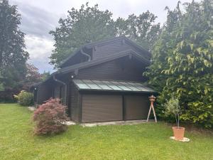 a garage with a gambrel roof in a yard at Idyllisches Einfamilienhaus bei München in Munich