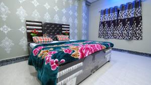1 dormitorio con 1 cama con un edredón colorido en Shree Krishna Niwas, en Deoghar