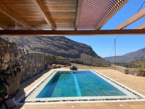 ein Schwimmbad in einem Haus mit Bergen im Hintergrund in der Unterkunft La casa vieja de la Montaña in Santa Lucía