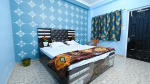 1 dormitorio con 1 cama grande y paredes azules en Shree Krishna Niwas en Deoghar