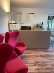 a waiting room with red chairs and a white counter at „1. SALZBURG work & sleep luxury apartment“ für arbeiten & wohnen ! in Salzburg