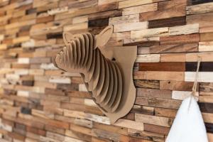 a wall made out of reclaimed wood with a bird sculpture at Appartement Uccelli - Cocoon just a stone's throw from the centre of Megève in Megève +11 photos