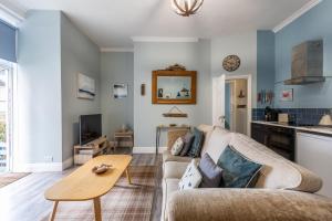 a living room with a couch and a table at Beach Snug in Lytham St Annes