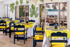 a restaurant with yellow tables and yellow chairs at Hotel Peten in Flores