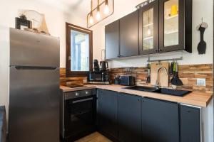 a kitchen with black cabinets and a stainless steel refrigerator at Appartement Uccelli - Cocoon just a stone's throw from the centre of Megève in Megève