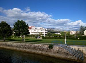 a building next to a body of water at Apartments Jasminka in Solin