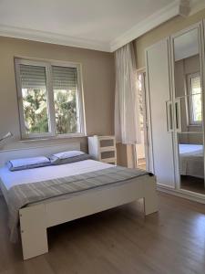 1 dormitorio con 1 cama grande y 2 ventanas en Room in the Peaceful Duplex-Lara2, en Antalya