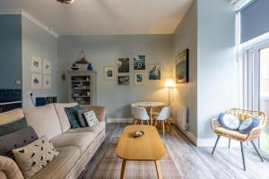 ein Wohnzimmer mit einem Sofa und einem Tisch in der Unterkunft Beach Snug in Lytham St Annes