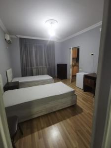 a bedroom with two beds and a desk in it at Apartment on Lado Asatiani in Batumi