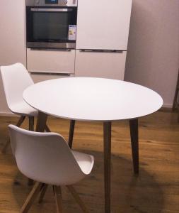 a white table and two white chairs in a kitchen at Sroom Metzingen in Metzingen