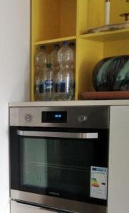 a microwave in a kitchen with bottles of water at Sroom Metzingen in Metzingen