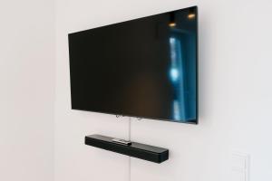 a flat screen tv hanging on a wall at Küsten Suite de See - Suite 1 direkte Deichlage, Terrasse, 53qm in Greetsiel