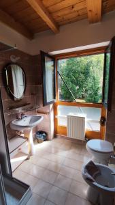 a bathroom with two sinks and a large window at Appartamenti Vacanze Lagolo in Lagolo di Calavino