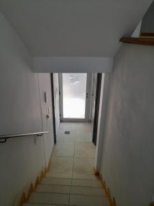 einen Flur mit einer Treppe, die zu einer Tür führt in der Unterkunft La casa de kiki Departamento excelente ubicación in Godoy Cruz