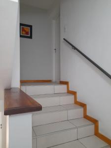 eine Treppe mit einer Holzschiene und einer Treppe in der Unterkunft La casa de kiki Departamento excelente ubicación in Godoy Cruz