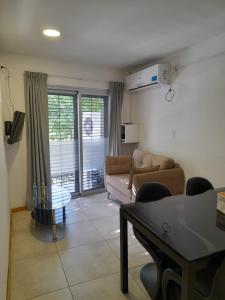 ein Wohnzimmer mit einem Sofa und einem Tisch in der Unterkunft La casa de kiki Departamento excelente ubicación in Godoy Cruz