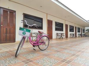 uma bicicleta rosa estacionada em frente a um edifício em Na Soi 5 Chiangkhan em Chiang Khan