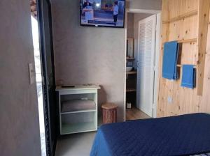 ein Schlafzimmer mit einem Bett und einem TV an der Wand in der Unterkunft Quarto Privativo em Santana de Parnaiba 02 in Santana de Parnaíba