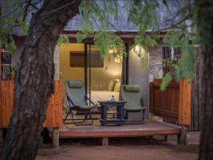 - deux chaises et une table sur une terrasse couverte dans l'établissement The Dreamcatcher Lodge, à Hoedspruit