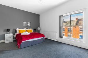 a bedroom with a bed and a large window at Palatial Six Bedroom Haven in Northampton