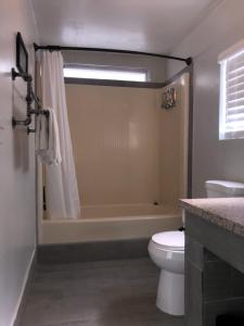 La salle de bains est pourvue d'une baignoire, de toilettes et d'un lavabo. dans l'établissement Olancha RV Park and Motel, à Olancha