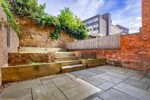 a brick wall with stairs and a fence at Palatial Six Bedroom Haven in Northampton