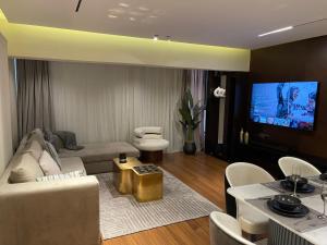 a living room with a couch and a tv at Family sumptuous apartment At Melsa - Nasr City. in Cairo
