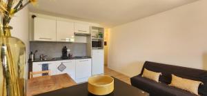 Una sala de estar con un sofá y una cocina. en Le Bellecroix, en Metz