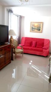 a living room with a red couch and a tv at Appartement d'une chambre avec terrasse et wifi a Paray Vieille Poste in Paray-Vieille-Poste