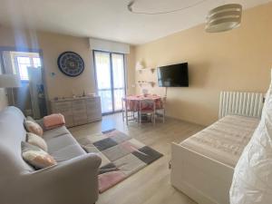 un soggiorno con divano e tavolo di la maison du soleil a Colazza
