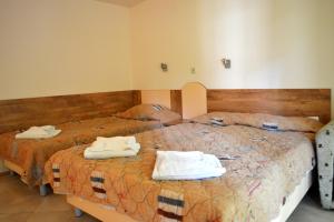 a bedroom with two beds with towels on them at Villas Ropotamo in Primorsko