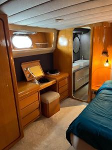 a bedroom with a bed and a sink and a mirror at Yacht Aquamarina vieux port La Rochelle in La Rochelle