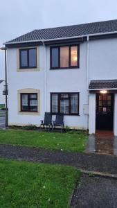 a white house with two benches in front of it at 2 Bedroom 1st floor flat Brean in Brean
