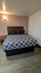 a bedroom with a bed with a black and white comforter at Portland Value Inn in Portland