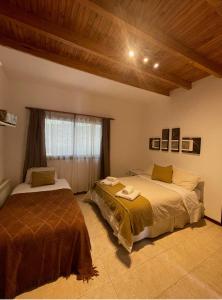 - une chambre avec 2 lits et une fenêtre dans l'établissement La Casa de la Laguna Vistalba, à Luján de Cuyo