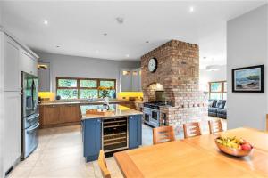 a kitchen with a table and a brick fireplace at Dunhill Cottage B&B in Hillsborough