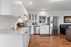 a kitchen with white cabinets and a stainless steel refrigerator at Private Mountainside Home in Chilliwack