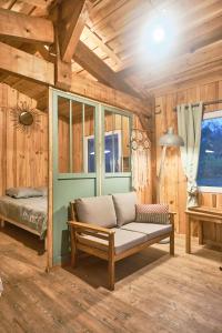 - un salon avec un canapé et un lit dans l'établissement Cabane de charme en pleine forêt - Domaine Temali, à Labouheyre