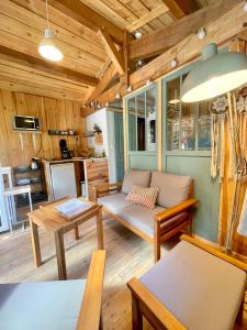 - un salon avec un canapé et une table dans l'établissement Cabane de charme en pleine forêt - Domaine Temali, à Labouheyre