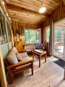 - un salon avec un canapé et une table dans l'établissement Cabane de charme en pleine forêt - Domaine Temali, à Labouheyre