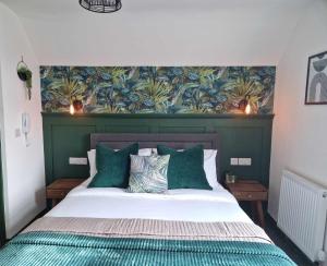 a bedroom with a large bed with a green headboard at The Coastal Hideaway in Bridlington