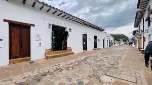 a cobblestone street in a town with white buildings at Hotel Caney Villa de Leyva by MH in Villa de Leyva
