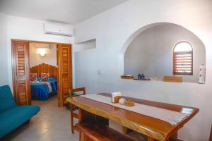 a living room with a table and a bedroom at Casa Colibrí Tankah in Tulum