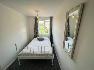 a small bedroom with a bed and a mirror at Stylish apartment in city centre in Oxford