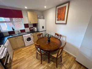 a kitchen with a table and chairs in a room at Stylish apartment in city centre in Oxford