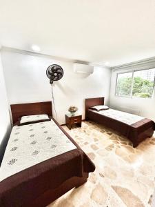 sypialnia z 2 łóżkami i wentylatorem w obiekcie Villa Magaly Manga - Centro Histórico w mieście Cartagena de Indias