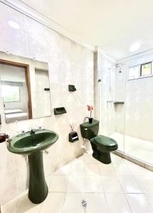 W łazience znajduje się zielona umywalka i toaleta. w obiekcie Villa Magaly Manga - Centro Histórico w mieście Cartagena de Indias