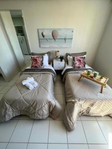a bedroom with two beds and a table on the floor at Travellar Spot 1225A in Ribeirão Preto