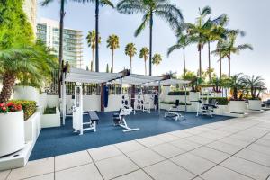 um pátio com cadeiras e palmeiras num resort em Luxury Condo in Marina del Rey with Pool em Los Angeles