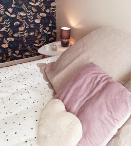 a bed with a heart shaped pillow and a table at Bienvenue au Gîte de Mornas in Beaumont-lès-Valence